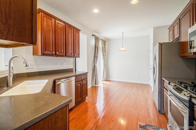 49761 Courtyard Ln, Canton, MI 48188 - kitchen with appliances with stainless steel finishes, dark countertops, light wood-style flooring, recessed lighting, and hanging light fixtures