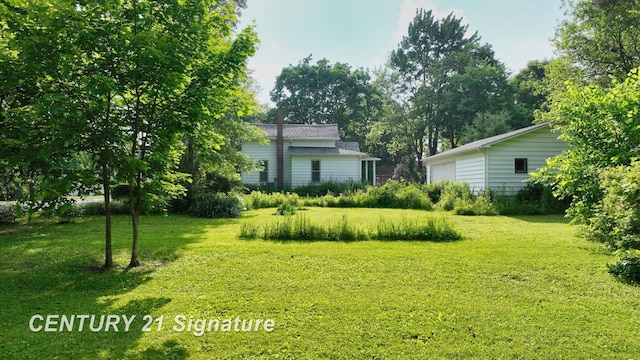 107 E Johns St, Durand, MI 48429 - view of green lawn featuring a garage