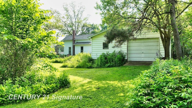 107 E Johns St, Durand, MI 48429 - view of grassy yard with a garage and driveway