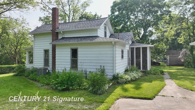 107 E Johns St, Durand, MI 48429 - view of property exterior with a chimney, a shingled roof, a lawn, and central AC unit