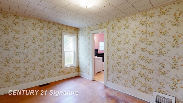 107 E Johns St, Durand, MI 48429 - spare room with wood finished floors, ornamental molding, and radiator