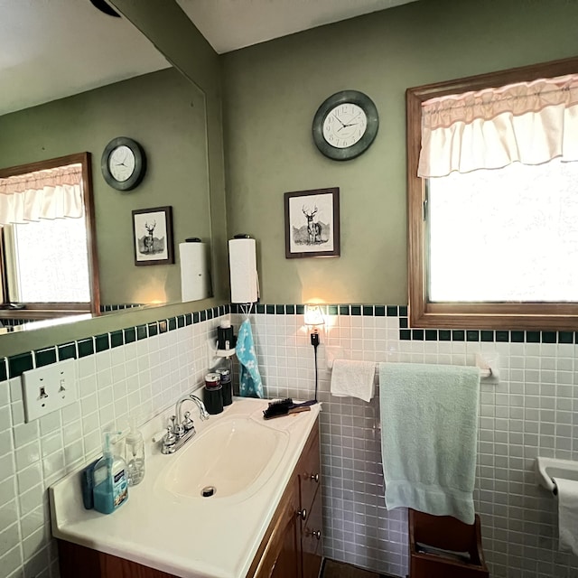 7484 Cedar Lake Rd, Oscoda, MI 48750 - bathroom featuring tile walls, vanity, and a wainscoted wall