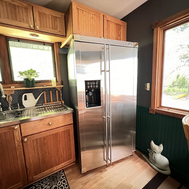 7484 Cedar Lake Rd, Oscoda, MI 48750 - kitchen with stainless steel fridge, a wainscoted wall, a sink, light wood-type flooring, and brown cabinetry