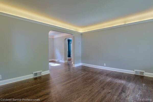 25811 Briarbank Ave, Southfield, MI 48033 - spare room featuring arched walkways, dark wood-style flooring, and baseboards