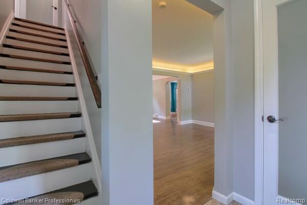 25811 Briarbank Ave, Southfield, MI 48033 - stairway featuring arched walkways, wood finished floors, and baseboards