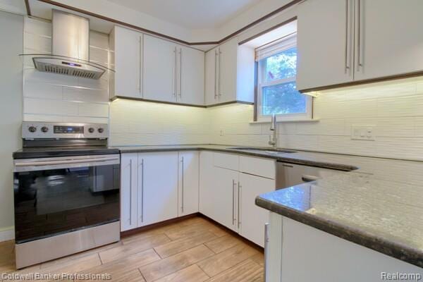 25811 Briarbank Ave, Southfield, MI 48033 - kitchen featuring stainless steel electric range oven, wall chimney exhaust hood, a sink, decorative backsplash, and light wood-style floors