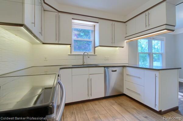 25811 Briarbank Ave, Southfield, MI 48033 - kitchen featuring dishwasher, stove, a sink, a peninsula, and decorative backsplash