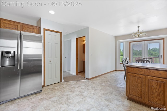 12172 Rynn Rd, Emmett, MI 48022 - kitchen featuring stainless steel fridge with ice dispenser, a chandelier, brown cabinets, and baseboards