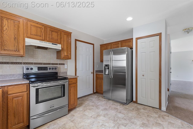 12172 Rynn Rd, Emmett, MI 48022 - kitchen with stainless steel appliances, under cabinet range hood, and brown cabinetry