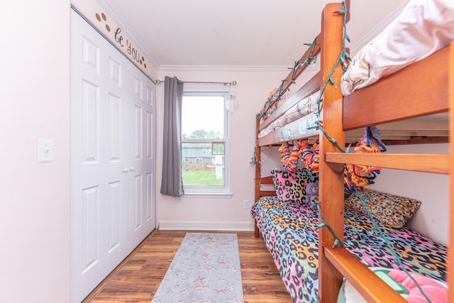386 Hartman Ln, Saline, MI 48176 - bedroom featuring ornamental molding, wood finished floors, baseboards, and a closet