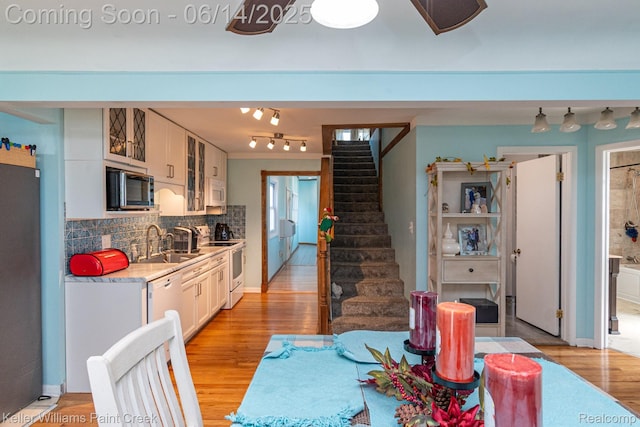 7359 Mckinley, Center Line, MI 48015 - kitchen with white appliances, light wood-style floors, light countertops, decorative backsplash, and glass insert cabinets