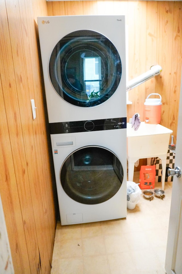 121 Houseman Ave NE, Grand Rapids, MI 49503 - laundry room featuring stacked washer / drying machine and wood walls