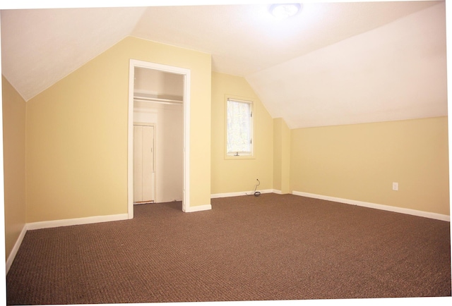 121 Houseman Ave NE, Grand Rapids, MI 49503 - additional living space with lofted ceiling, dark colored carpet, and baseboards