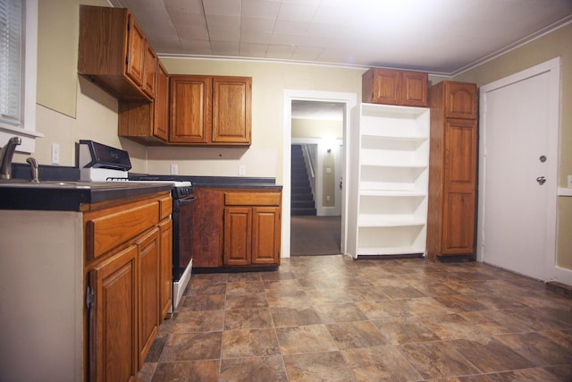 121 Houseman Ave NE, Grand Rapids, MI 49503 - kitchen with black range, dark countertops, brown cabinetry, crown molding, and stone finish floors
