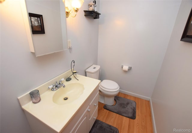 5483 Ameno Ln, Swartz Creek, MI 48473 - half bath with wood finished floors, vanity, toilet, and baseboards