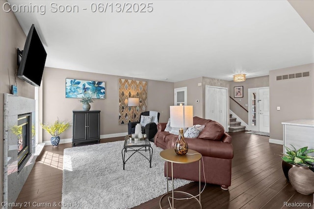 619 Winwood Cir, Walled Lake, MI 48390 - living area with hardwood / wood-style floors, a glass covered fireplace, and stairway