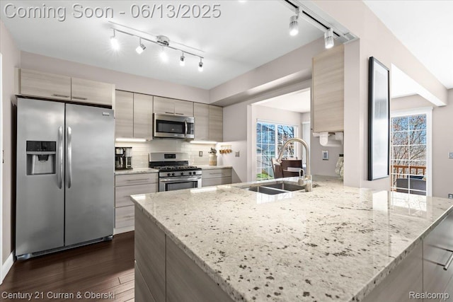 619 Winwood Cir, Walled Lake, MI 48390 - kitchen with appliances with stainless steel finishes, rail lighting, dark wood finished floors, a peninsula, and modern cabinets