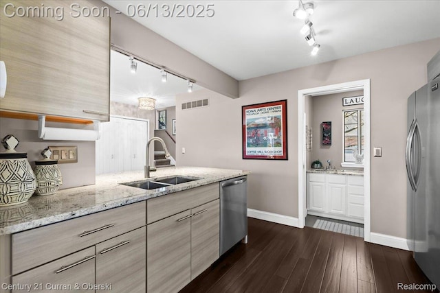 619 Winwood Cir, Walled Lake, MI 48390 - kitchen with rail lighting, stainless steel appliances, dark wood finished floors, light stone countertops, and a peninsula
