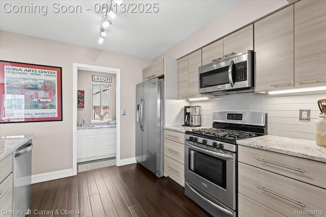 619 Winwood Cir, Walled Lake, MI 48390 - kitchen with stainless steel appliances, dark wood-style floors, tasteful backsplash, light stone countertops, and rail lighting