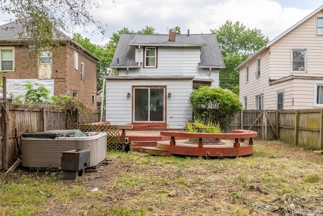 218 Clifford St, Lansing, MI 48912 - rear view of property featuring a deck, a shingled roof, a hot tub, a chimney, and a fenced backyard