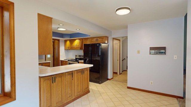 160 Wire Line Rd, Caro, MI 48723 - kitchen with black fridge with ice dispenser, stainless steel range with electric stovetop, a peninsula, brown cabinetry, and baseboards