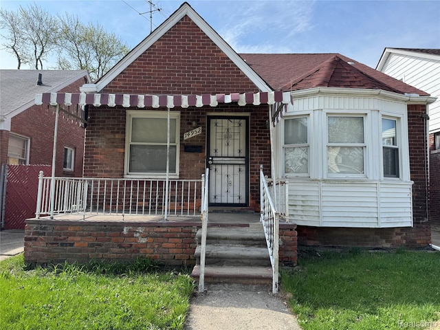 14952 Elmdale St, Detroit, MI 48213 - bungalow featuring covered porch, brick siding, and a shingled roof