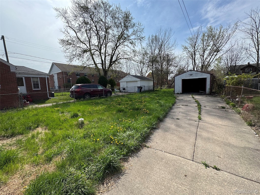 14952 Elmdale St, Detroit, MI 48213 - view of yard featuring a detached garage, an outdoor structure, and driveway