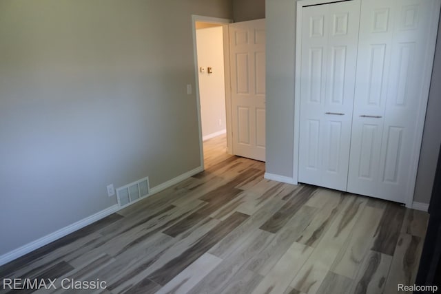 3132 N Monroe St, Monroe, MI 48162 - unfurnished bedroom featuring wood finished floors, baseboards, and a closet