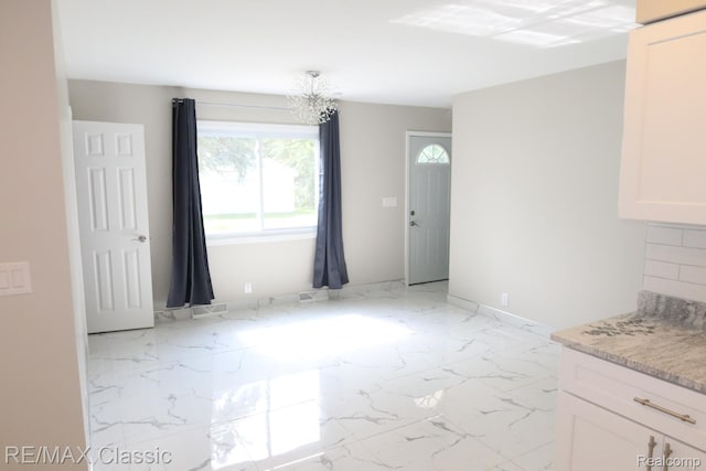 3132 N Monroe St, Monroe, MI 48162 - unfurnished dining area with light marble finish floors and a chandelier