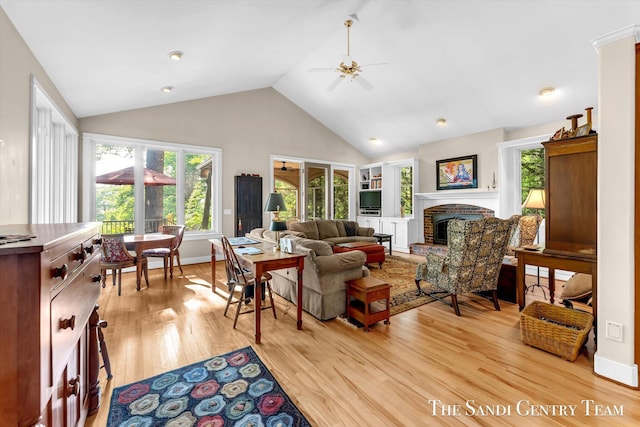 8985 Lakeshore Dr, West Olive, MI 49460 - living room with light wood-type flooring, ceiling fan, a brick fireplace, high vaulted ceiling, and baseboards