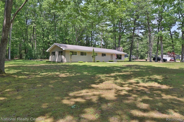 10475 W Higgins Lake Dr, Roscommon, MI 48653 - view of front of home featuring a chimney and a front lawn