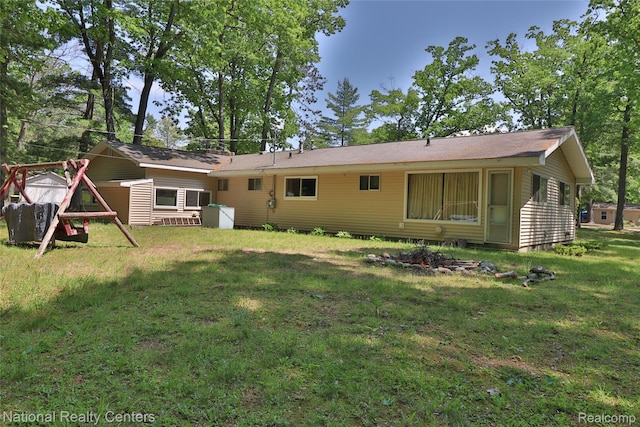 10475 W Higgins Lake Dr, Roscommon, MI 48653 - back of house featuring a lawn