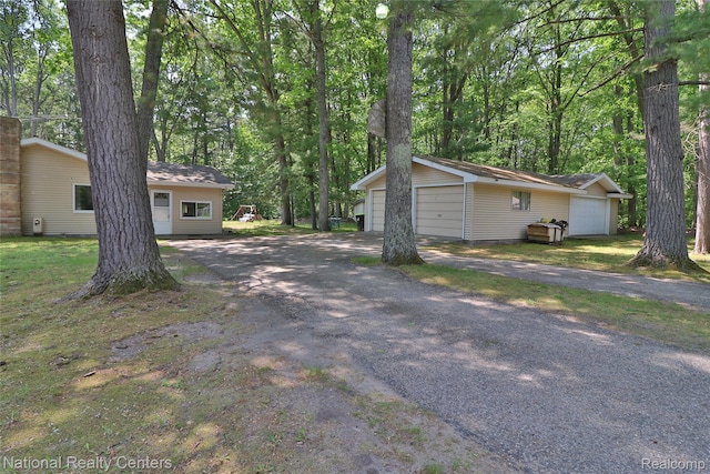 10475 W Higgins Lake Dr, Roscommon, MI 48653 - view of property exterior with a detached garage and an outbuilding