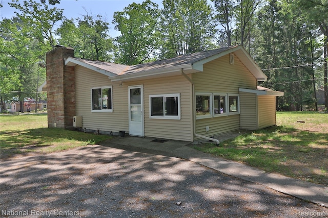 10475 W Higgins Lake Dr, Roscommon, MI 48653 - view of front of property with a chimney and roof with shingles