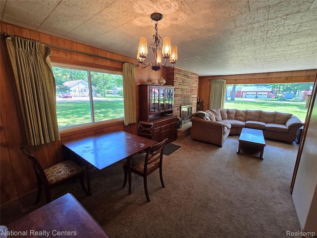 10475 W Higgins Lake Dr, Roscommon, MI 48653 - dining area with a chandelier, carpet flooring, wooden walls, and healthy amount of natural light
