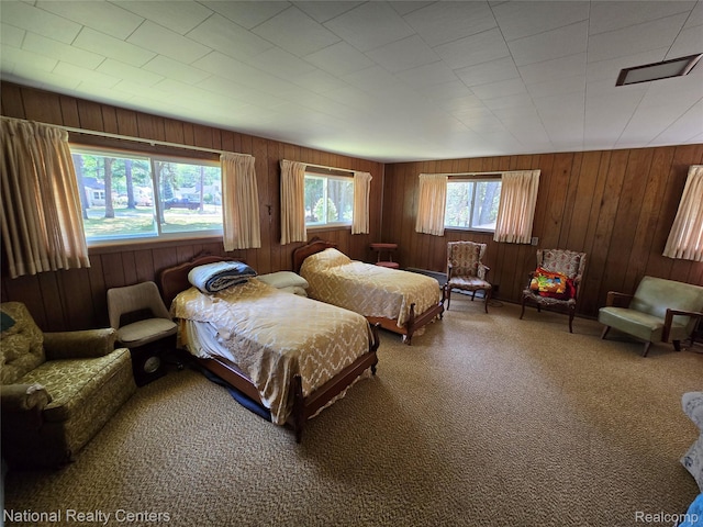 10475 W Higgins Lake Dr, Roscommon, MI 48653 - bedroom with carpet floors and wood walls