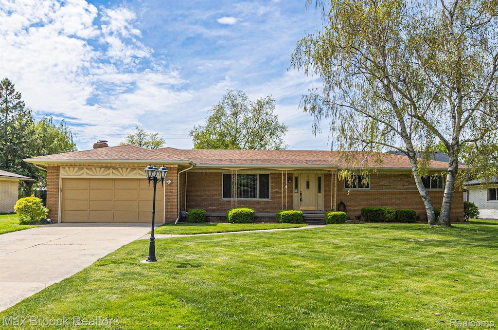 37639 Irene Dr, Sterling Heights, MI 48312 - ranch-style house with brick siding, an attached garage, concrete driveway, and a front lawn