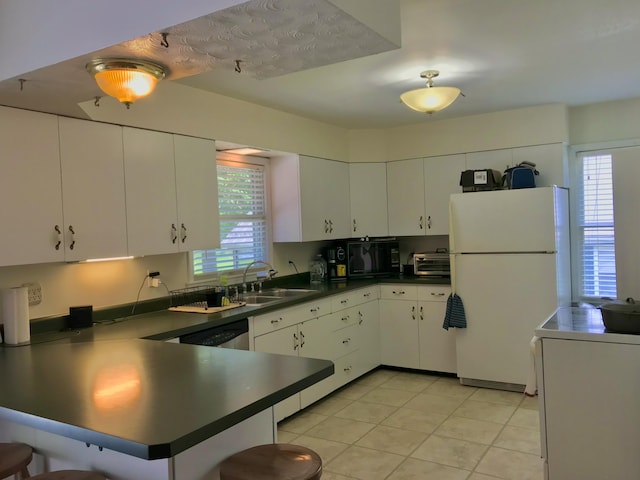 66223 Grey Lake Rd, Sturgis, MI 49091 - kitchen featuring freestanding refrigerator, black microwave, a sink, a peninsula, and dark countertops