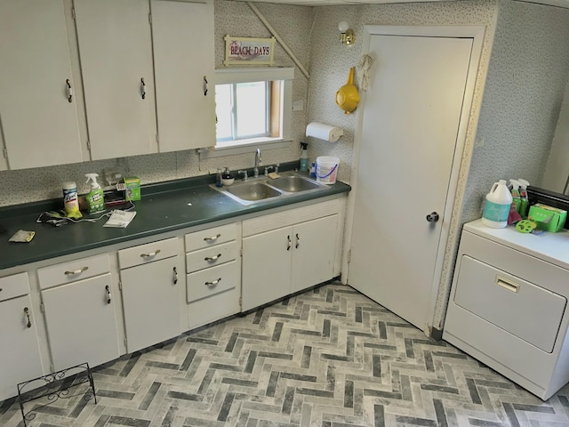 66223 Grey Lake Rd, Sturgis, MI 49091 - kitchen featuring a sink, washer / clothes dryer, dark countertops, and white cabinetry