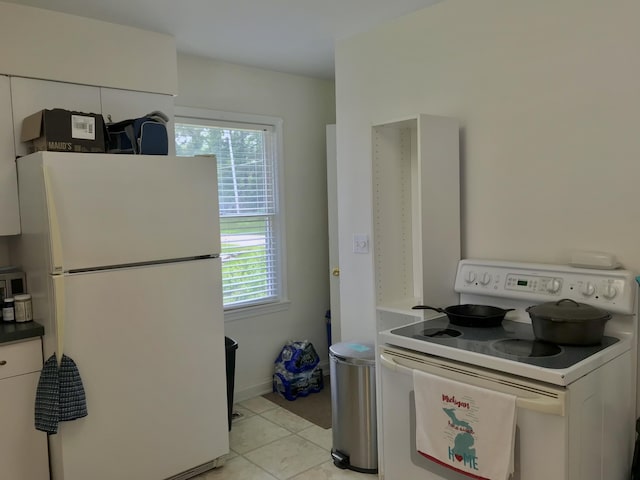 66223 Grey Lake Rd, Sturgis, MI 49091 - kitchen with white appliances, white cabinets, and light tile patterned flooring