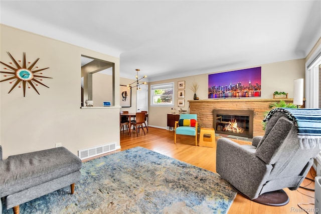 4006 Highfield Rd, Royal Oak, MI 48073 - living area featuring wood finished floors, a brick fireplace, a chandelier, and baseboards
