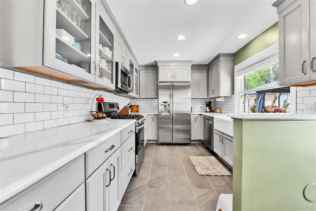4006 Highfield Rd, Royal Oak, MI 48073 - kitchen with stainless steel appliances, gray cabinets, backsplash, recessed lighting, and glass insert cabinets