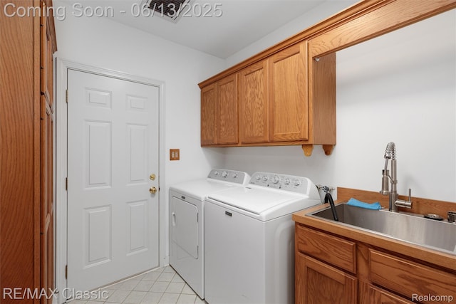 8173 Earhart Rd, South Lyon, MI 48178 - laundry room featuring cabinet space, washing machine and dryer, and light tile patterned flooring