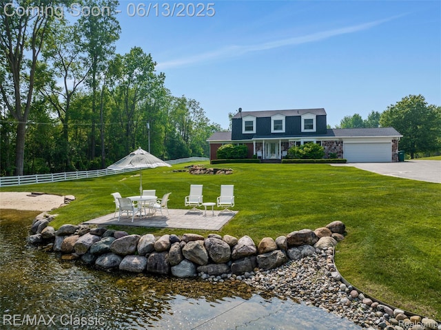 8173 Earhart Rd, South Lyon, MI 48178 - view of yard featuring an attached garage, a patio, driveway, and a water view