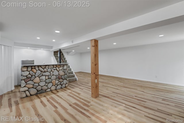 8173 Earhart Rd, South Lyon, MI 48178 - finished below grade area with wood finished floors, recessed lighting, baseboards, bar area, and stairway