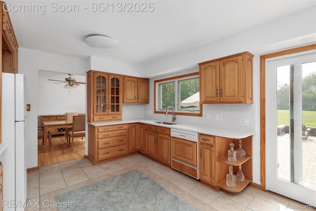 8173 Earhart Rd, South Lyon, MI 48178 - kitchen featuring dishwasher, freestanding refrigerator, a sink, light countertops, and glass insert cabinets