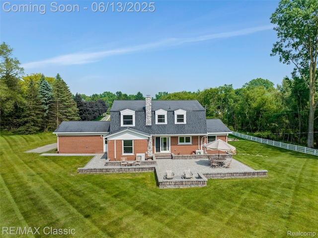 8173 Earhart Rd, South Lyon, MI 48178 - back of house with brick siding, a patio area, a chimney, entry steps, and a wooded view