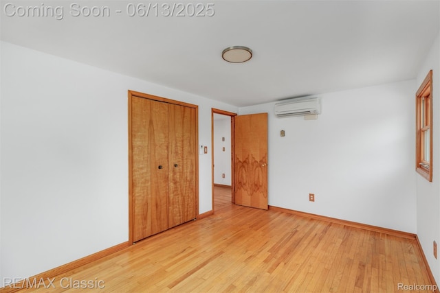 8173 Earhart Rd, South Lyon, MI 48178 - unfurnished bedroom featuring an AC wall unit, light wood finished floors, a closet, and baseboards