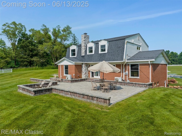 8173 Earhart Rd, South Lyon, MI 48178 - rear view of house with a chimney, a yard, brick siding, and a patio area