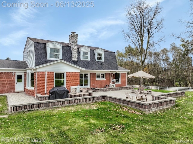 8173 Earhart Rd, South Lyon, MI 48178 - rear view of property with a patio, a chimney, brick siding, a gambrel roof, and a shingled roof